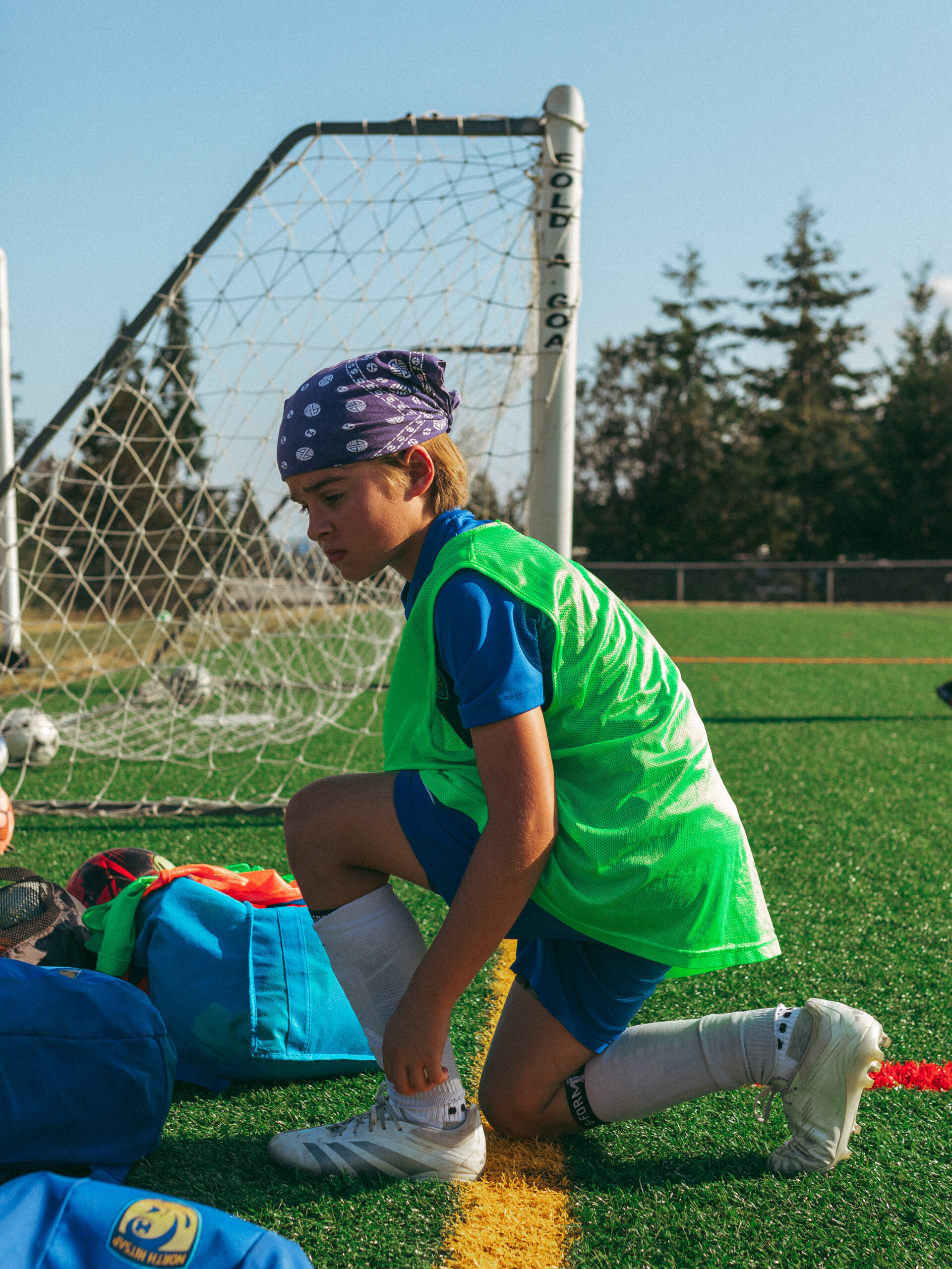 A NKSC soccer player ties his shoes before returning to play.